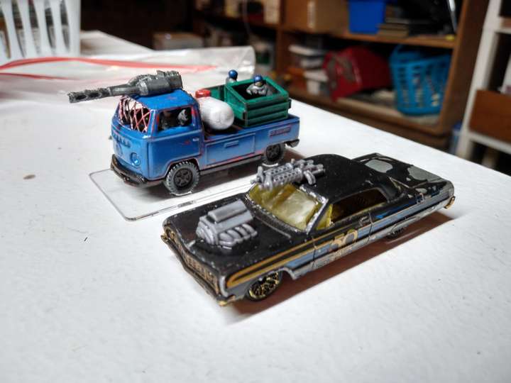 2 Matchbox toy cars with neat 3d printed guns and equipment attached